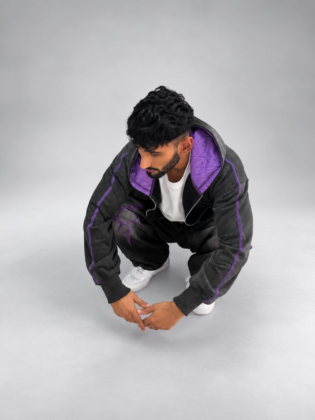 Model crouching in the Drop 001 hoodie