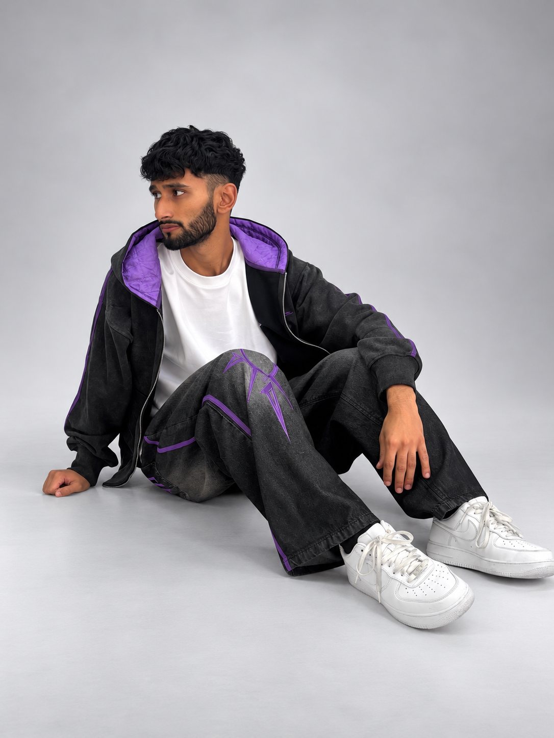 Model seated in the Drop 001 hoodie and jeans